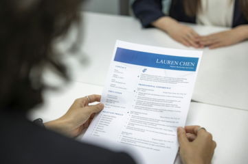 a woman is reading a resume at a table